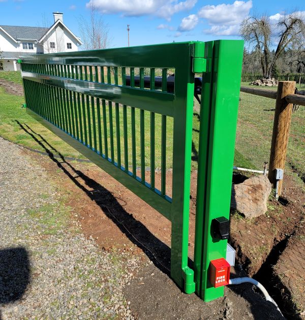 Completed automatic gate installation of a green driveway gate in Beaverton OR by All About Garage Doors