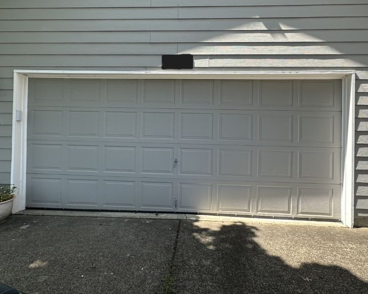 Light grey home and garage door before an emergency garage door service by All About Garage Doors in Tigard OR
