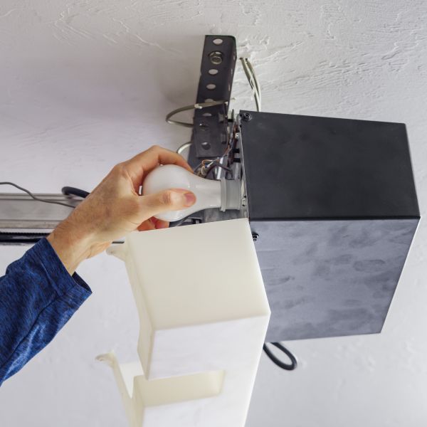 Replacing a lightbulb during garage door maintenance by the team at All About Garage Doors in Lake Oswego OR