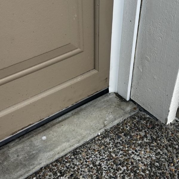 Old weatherstripping on the bottom of a garage door before getting replaced during a garage door repair by All About Garage Doors in Raleigh Hills OR
