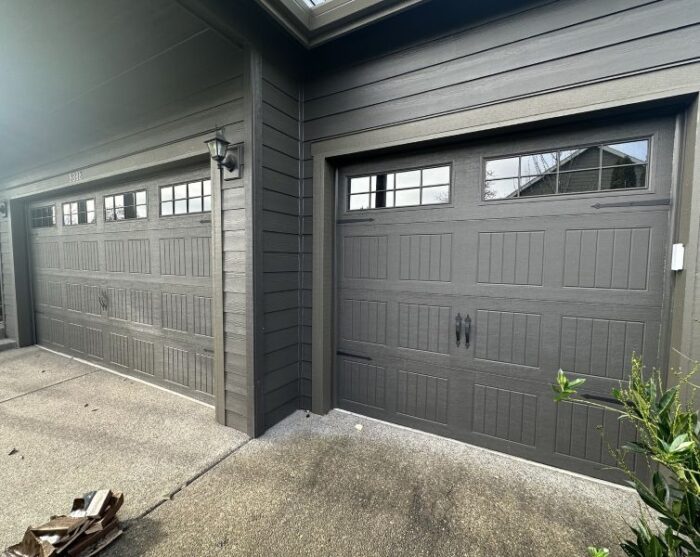 Dark home with dark, windowed garage doors utilizes the expert services of All About Garage Doors in Raleigh Hills OR