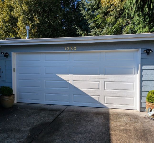 Pale blue home in Bridlemile Portland OR utilizes the expert services by All About Garage Doors, a local garage door company