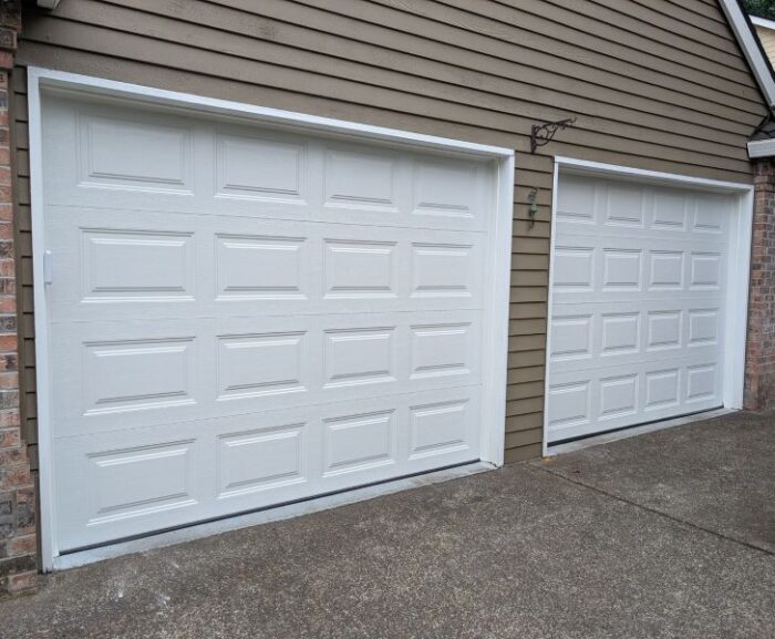 Two white garage doors on a tan home trusts All About Garage Doors for expert garage door services in Raleigh Hills OR